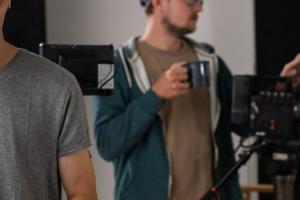 Α’ Βοηθός Εικονολήπτη ετοιμάζει τον φακό της κάμερας με τον οπερατέρ στο βάθος